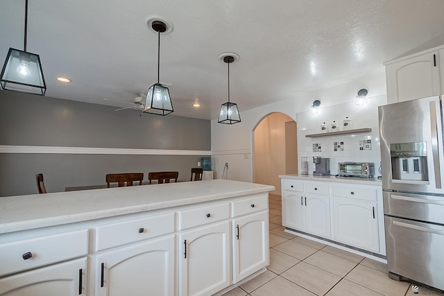 kitchen with white cabinetry, light tile patterned floors, stainless steel fridge with ice dispenser, and pendant lighting