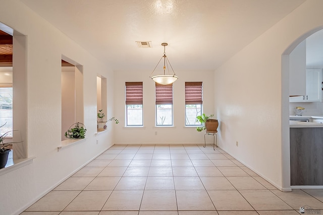 unfurnished dining area featuring light tile patterned flooring