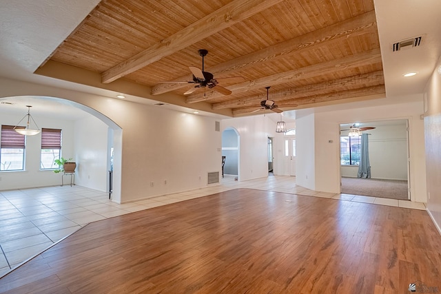 empty room with wood ceiling, beamed ceiling, ceiling fan, and light wood-type flooring