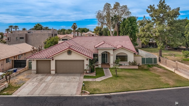 mediterranean / spanish-style home featuring a garage and a front lawn