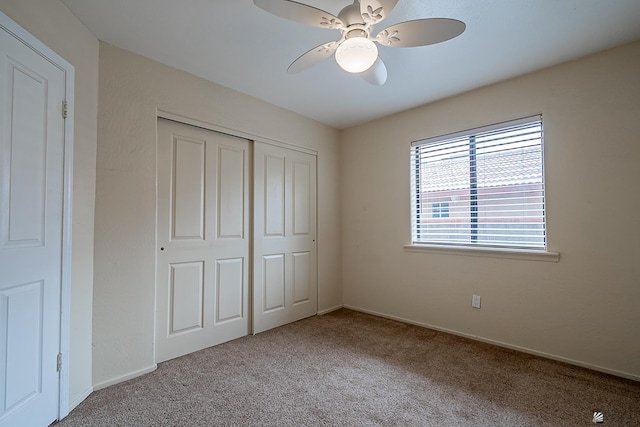 unfurnished bedroom with light colored carpet, a closet, and ceiling fan