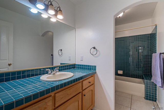 bathroom with tile patterned flooring, vanity, and tiled shower / bath combo