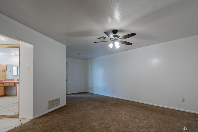 spare room with light colored carpet and ceiling fan