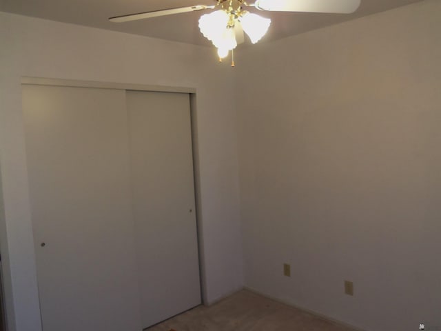 unfurnished bedroom featuring a ceiling fan and a closet