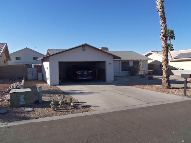 ranch-style home with a garage, concrete driveway, fence, and stucco siding