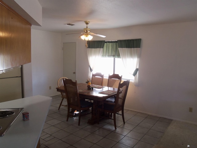 dining space with baseboards, visible vents, a ceiling fan, and light tile patterned flooring