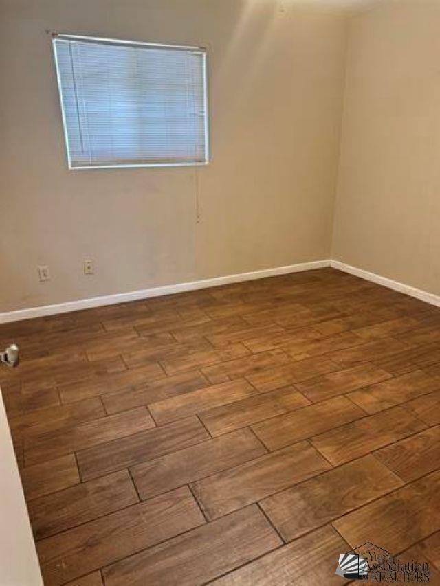 unfurnished room featuring wood finished floors and baseboards