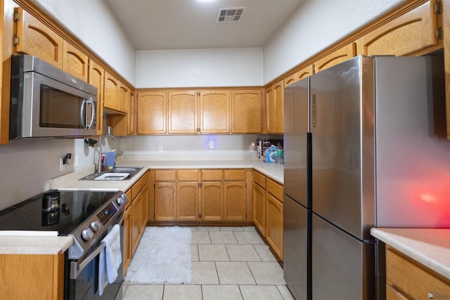 kitchen featuring sink, light tile patterned flooring, and appliances with stainless steel finishes