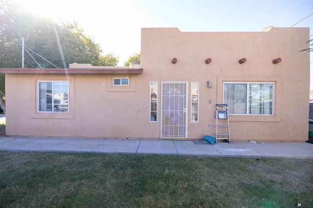 rear view of house featuring a yard and a patio