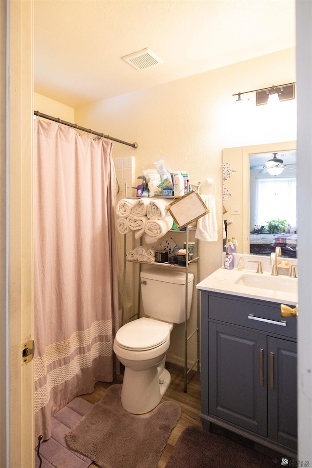 bathroom featuring vanity, hardwood / wood-style floors, curtained shower, and toilet