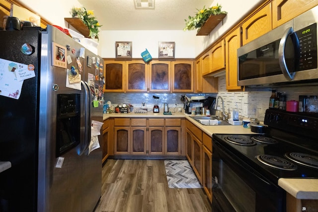 kitchen featuring tasteful backsplash, appliances with stainless steel finishes, sink, and dark wood-type flooring