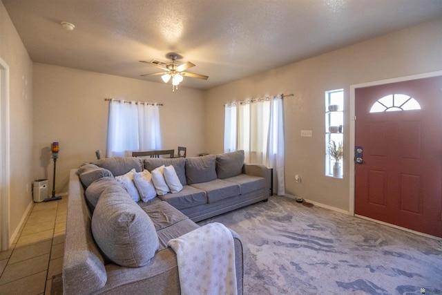 living room with ceiling fan and a textured ceiling