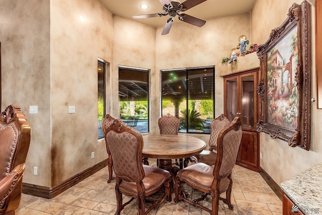 dining area with ceiling fan and a high ceiling