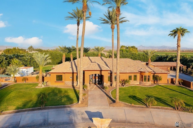 view of front of house with a mountain view and a front lawn