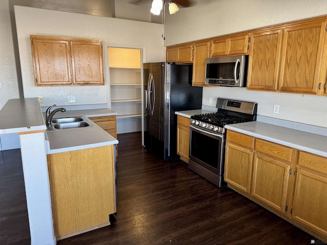 kitchen featuring stainless steel appliances, ceiling fan, dark wood-type flooring, and sink