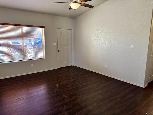 unfurnished room with ceiling fan and dark wood-type flooring