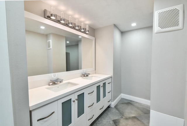 bathroom with double sink, vanity with extensive cabinet space, and tile flooring