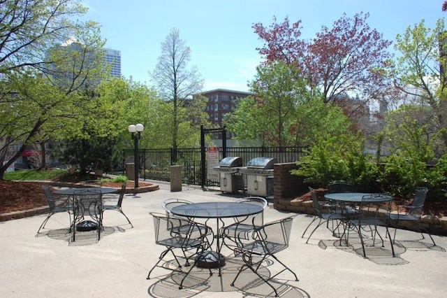 view of patio / terrace with exterior kitchen, outdoor dining space, fence, and grilling area