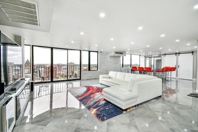 living room with floor to ceiling windows, recessed lighting, visible vents, a barn door, and an AC wall unit