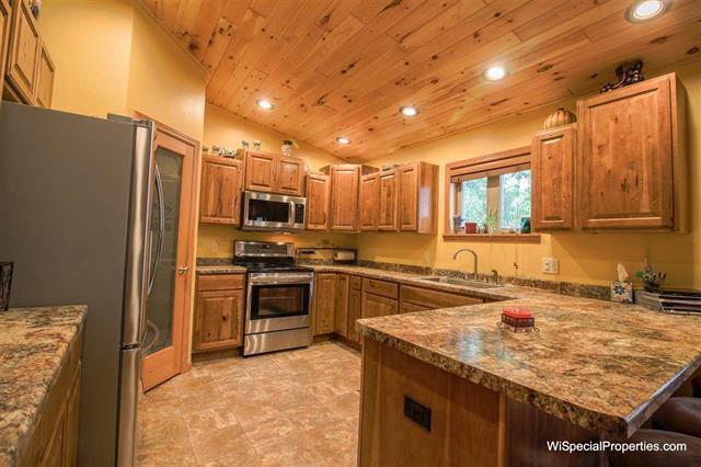 kitchen with sink, wood ceiling, stainless steel appliances, light tile flooring, and lofted ceiling