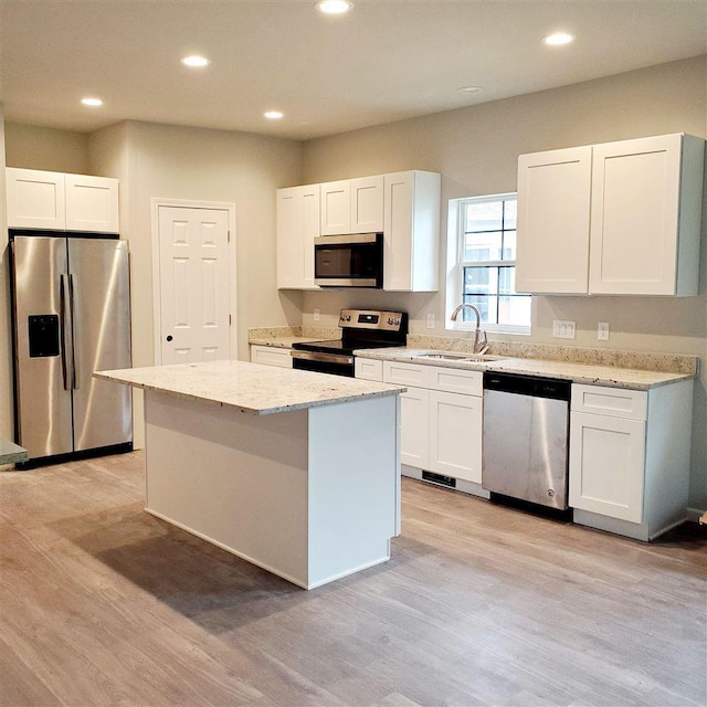 kitchen featuring white cabinetry, a center island, light hardwood / wood-style floors, and appliances with stainless steel finishes