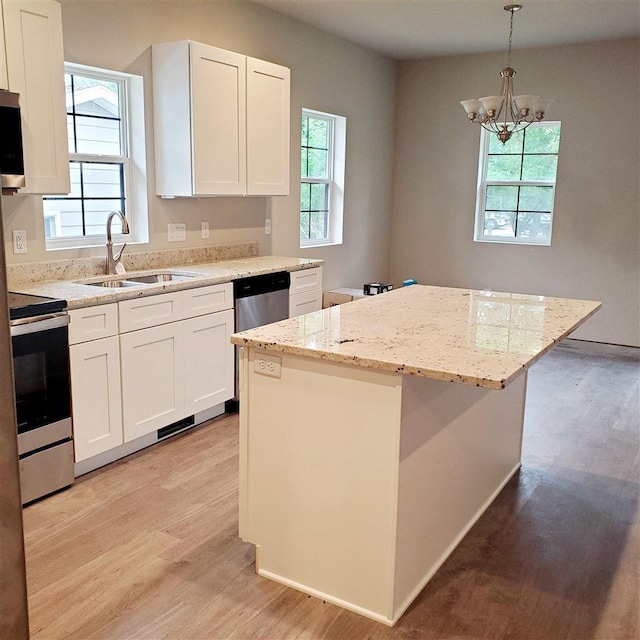 kitchen featuring light hardwood / wood-style flooring, a center island, a healthy amount of sunlight, and white cabinets