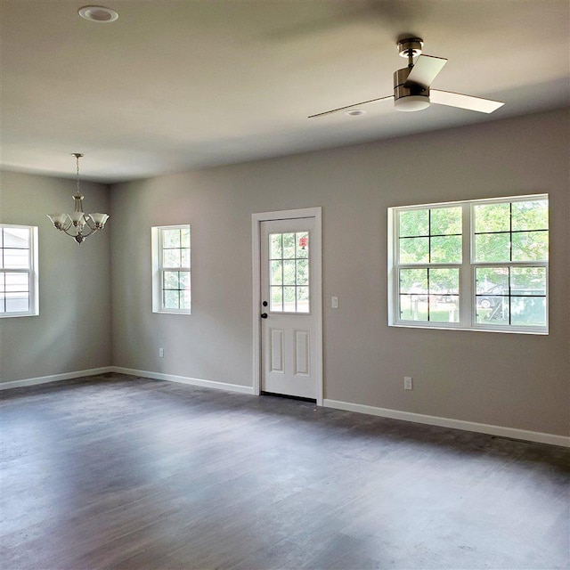 interior space with ceiling fan with notable chandelier and wood-type flooring