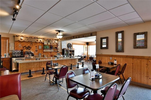 carpeted dining space with a paneled ceiling