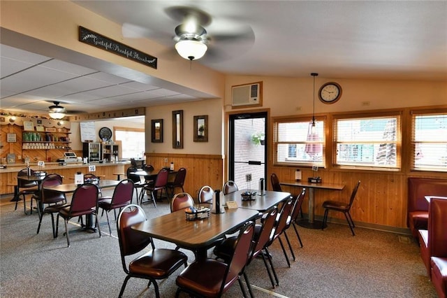 carpeted dining space with ceiling fan and vaulted ceiling