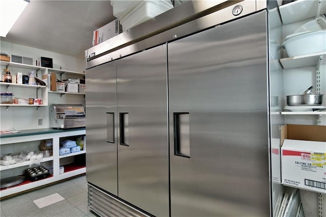 interior space with light tile flooring and high end fridge