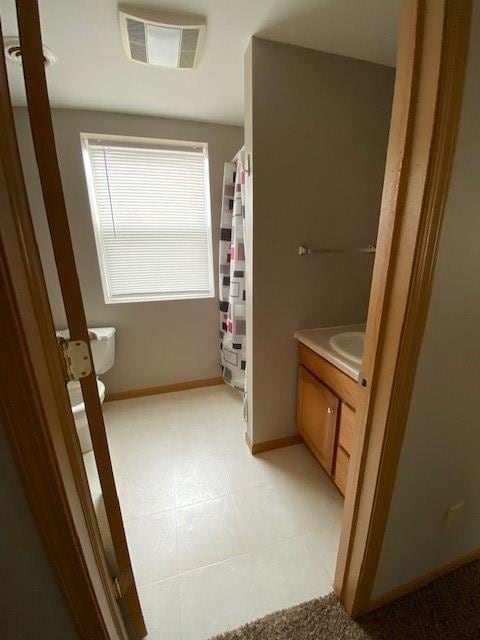 bathroom with tile flooring, toilet, and vanity