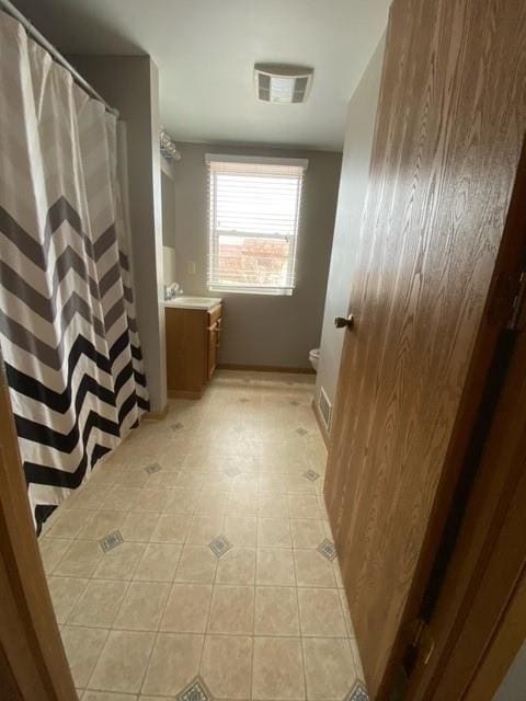 bathroom with toilet, tile floors, and vanity