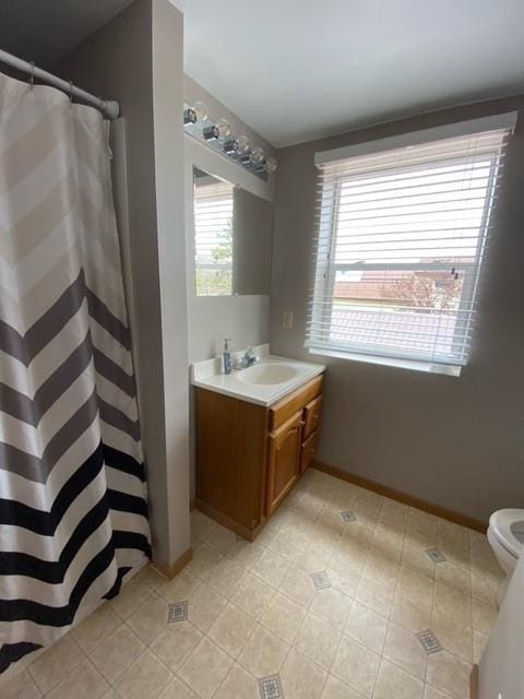 bathroom featuring toilet, vanity, and tile flooring