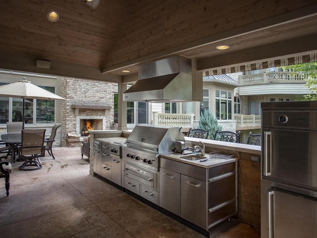 view of patio with a balcony, a fireplace, a grill, sink, and area for grilling