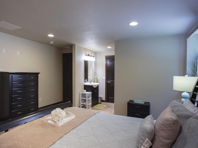 bedroom featuring connected bathroom and sink