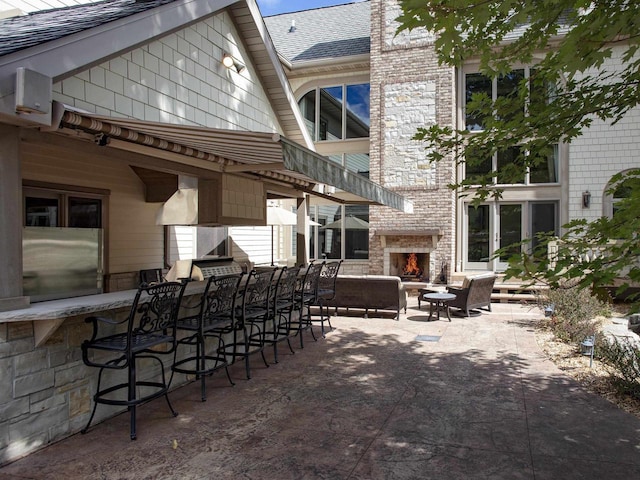 view of patio / terrace with an outdoor bar and an outdoor brick fireplace