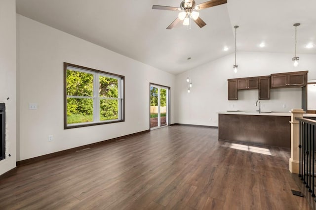 unfurnished living room featuring ceiling fan, sink, dark wood-type flooring, and high vaulted ceiling