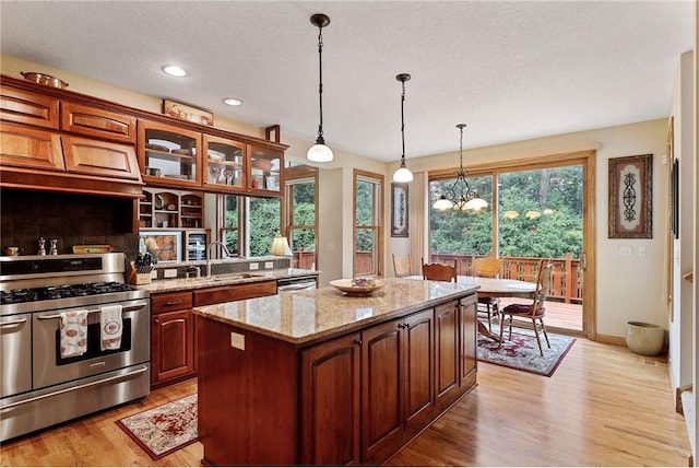 kitchen featuring a center island, light wood-type flooring, a chandelier, and range with two ovens