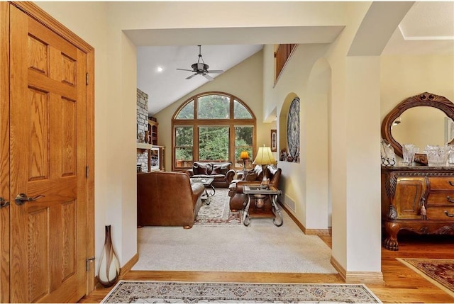 foyer entrance featuring lofted ceiling, ceiling fan, and light hardwood / wood-style flooring