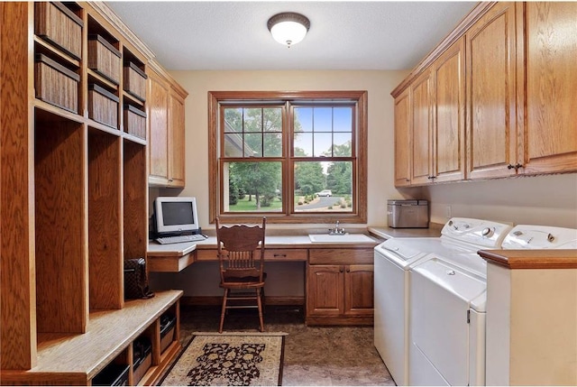 clothes washing area with dark tile floors, separate washer and dryer, sink, and cabinets