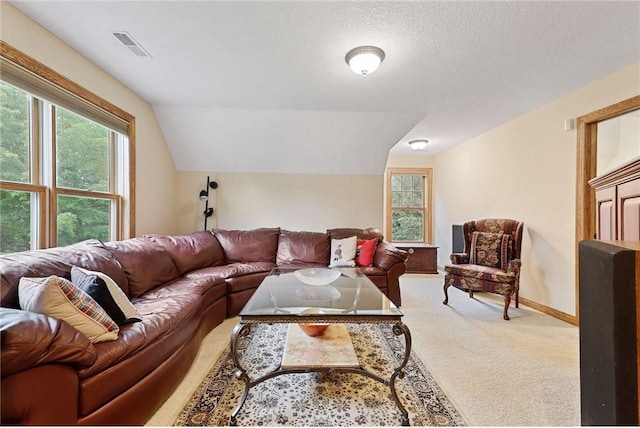 living room featuring a textured ceiling, plenty of natural light, light carpet, and vaulted ceiling