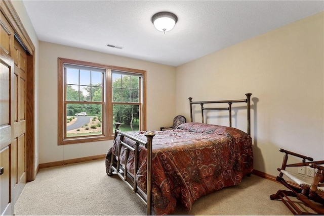 carpeted bedroom featuring a closet and a textured ceiling