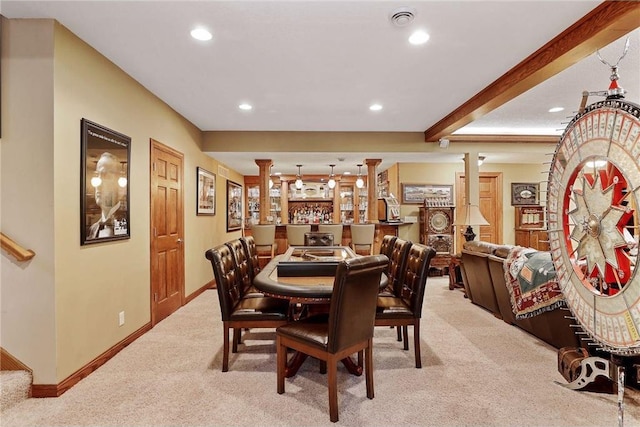 carpeted dining area with beamed ceiling and ornate columns