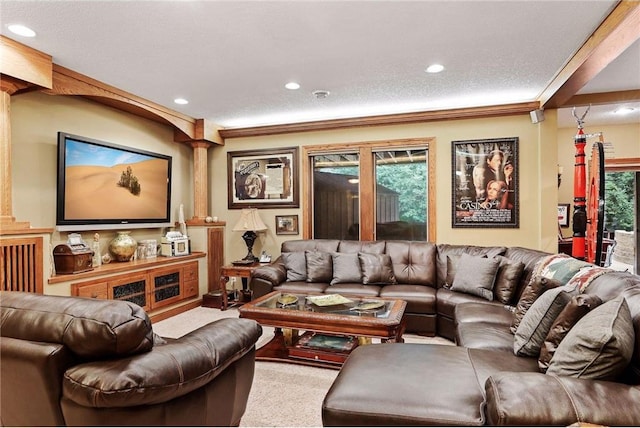 carpeted living room with decorative columns and a textured ceiling