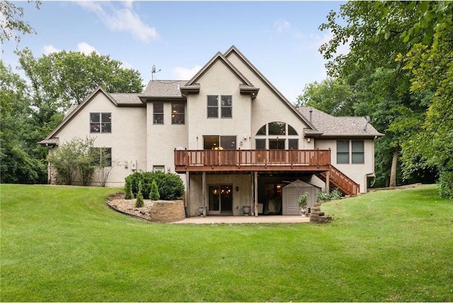 rear view of house with a wooden deck, a patio area, and a yard