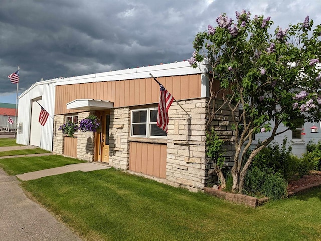 view of horse barn with a lawn