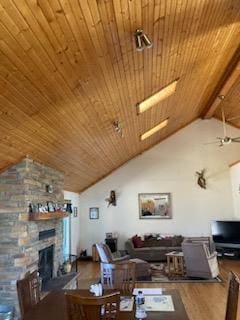 living room featuring vaulted ceiling with beams, ceiling fan, hardwood / wood-style flooring, and a fireplace