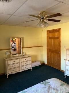 unfurnished bedroom featuring a paneled ceiling and carpet floors