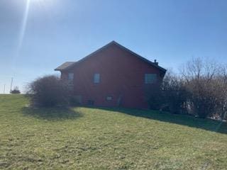 view of side of home with a lawn