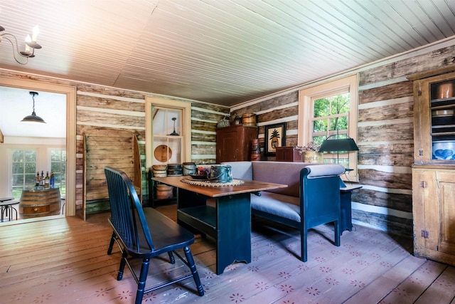 dining room featuring rustic walls, wood walls, wooden ceiling, and light wood-type flooring